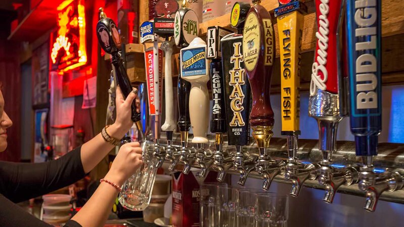 Multiple beer taps with beer being poured into a glass